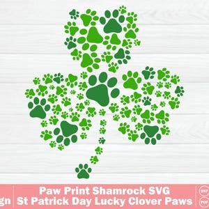 Puede incluir: Un diseño de trébol verde hecho de huellas de patas de varios tamaños, sobre un fondo de madera blanca. El texto en la parte inferior dice "01 Design Paw Print Shamrock SVG St Patrick Day Lucky Clover Paws".