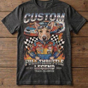 May include: Dark gray t-shirt featuring a dog wearing sunglasses and a racing jacket, with the text "CUSTOM" above the dog. The shirt also has racing cars and the words "FULL THROTTLE LEGEND TRACK CHAMPION".