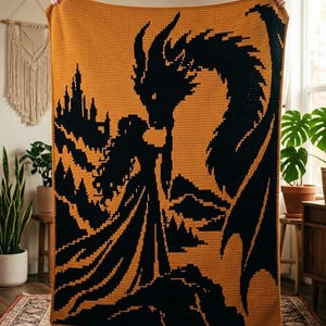 Può includere: Una coperta rettangolare all'uncinetto con un design ad alto contrasto in giallo senape e nero. Il motivo raffigura la sagoma di un grande drago di fronte a una figura umana davanti a un castello, in uno stile grafico pixelato.