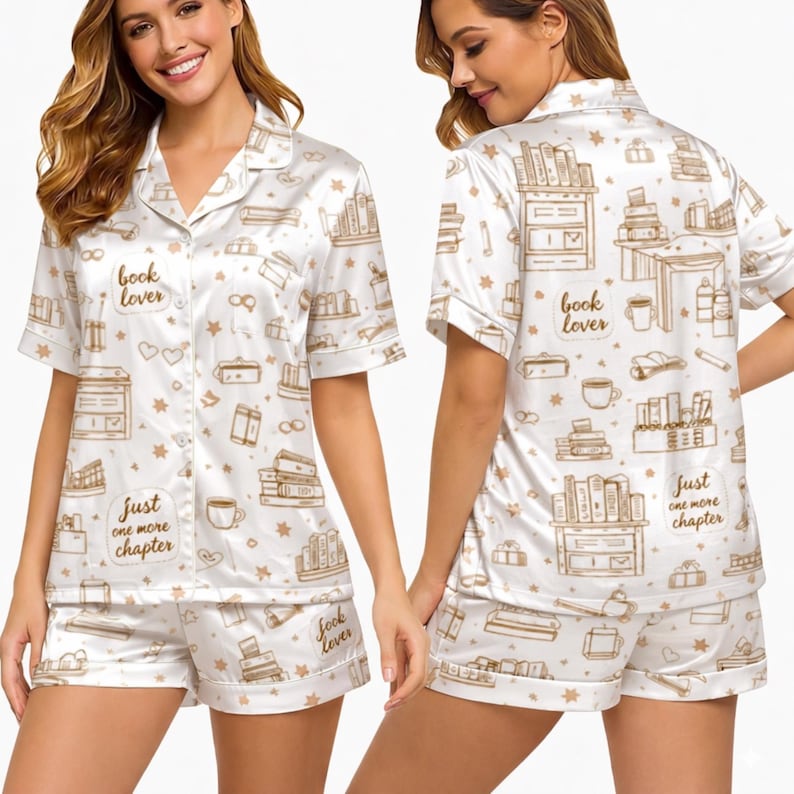 May include: White satin pajama set with a book-themed print. The set includes a short-sleeved button-down shirt and matching shorts. The print features books, coffee cups, and the phrases "book lover" and "just one more chapter."
