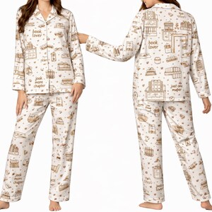 May include: White pajama set with a repeating pattern of books, gifts, and coffee cups in brown. The top has a collared neckline and button closure. Text on the pajamas reads "book lover" and "just one more chapter".