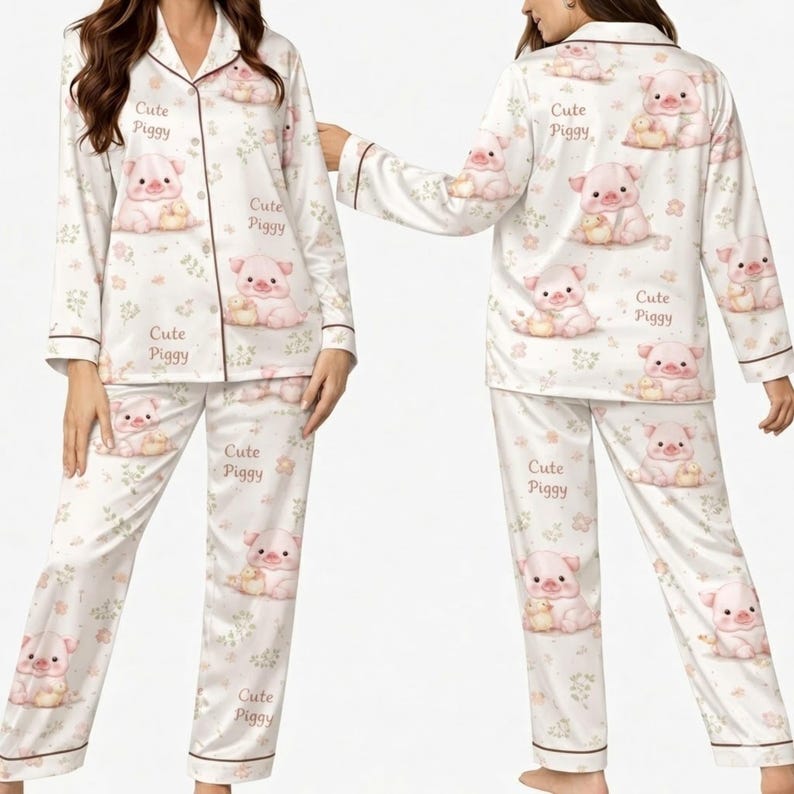 May include: White pajama set with a repeating pattern of pink pigs and the text "Cute Piggy". The long-sleeved top and pants have brown trim and a floral design. The pajama set is made of a soft, silky material.