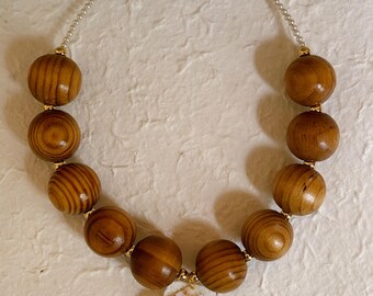 one of a kind wooden and freshwater pearl beaded necklace with seashell pendant and gold components