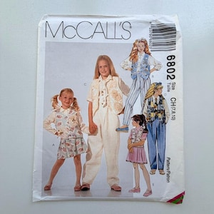 Peut inclure: Enveloppe de patron de couture McCall's présentant des modèles de vêtements pour enfants. L'enveloppe affiche différentes tenues, dont un ensemble jupe, un tailleur pantalon et des robes. La taille est CH (7,8,10).