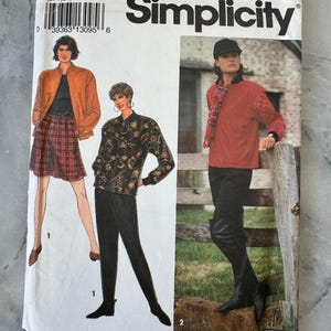 Pode incluir: Um pacote de padrões de costura Simplicity vintage, com ilustrações de designs de roupas femininas. O pacote é branco com o logotipo Simplicity e detalhes do produto. Os designs incluem um casaco, saia, calças e um top acolchoado.