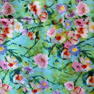 May include: A white ceramic mug with a black handle and the text "But First, Coffee" in a bold, black font. The mug is set against a blurred background, suggesting a cozy setting.