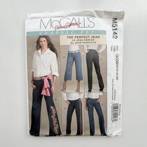 May include: A McCall's M5142 sewing pattern envelope for The Perfect Jean. The front features a model wearing dark blue jeans with floral embroidery and a pink sash, alongside illustrations of four jean variations in sizes GGW 20-22-24-26.