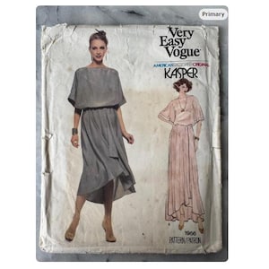 May include: Vintage Very Easy Vogue sewing pattern featuring a dress design by Kasper. The pattern cover shows a woman in a gray dress and a drawing of a woman in a pink dress. The pattern number is 1956.
