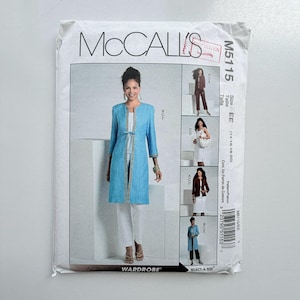 Op de afbeelding: Een McCall's M5115 naaipatroon-envelop voor een garderobeset. De voorzijde toont een lichtblauw lang jasje met een striksluiting en een witte broek. Kleinere afbeeldingen tonen variaties, waaronder een donker jasje en een witte jurk.