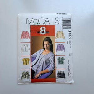 Może przedstawiać: Wzór krawiecki McCall's 2128. Na kopercie wzoru znajduje się kobieta w jasnofioletowym topie i ilustracje różnych stylów kurtek. Tekst na kopercie zawiera "Great Looks" i "1 Easy Pattern".