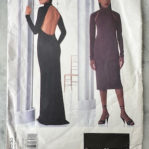 Może przedstawiać: Wzór do szycia w stylu vintage przedstawiający dwie długie sukienki. Jedna to czarna suknia z odkrytymi plecami i długimi rękawami. Druga to ciemnofioletowa sukienka z długimi rękawami i wysokim dekoltem. Wzór oznaczony jest jako "ISAAC MIZRAHI".