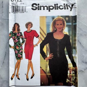 May include: A vintage Simplicity sewing pattern packet. The white packet features illustrations of three dresses, a woman, and the Simplicity logo. The pattern number is 8122, and the size is P (12-16).
