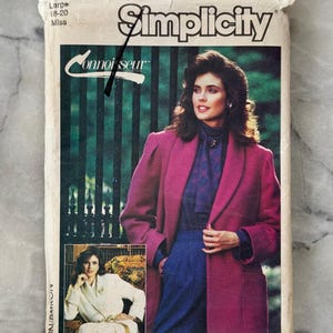 May include: Vintage Simplicity Connoisseur sewing pattern. The pattern features a woman wearing a magenta coat, blue trousers, and a patterned blouse. The pattern is for sizes 18-20.