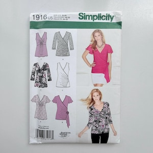 May include: A Simplicity 1916 sewing pattern envelope for sizes U.S. 16-24. The package displays illustrations of six different wrap-style top variations with various sleeve lengths and patterns, alongside photographs of two finished tops in pink and floral.