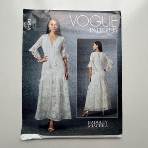 Op de afbeelding: Vogue Patterns V1693 naaipatroon met een witte kanten jurk met klokmouwen en een rok met ruches. Het patroon bevat een tweede afbeelding van de jurk. Het Vogue Patterns-logo staat bovenaan.