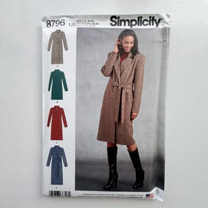 May include: A Simplicity sewing pattern envelope 8796 for a long-sleeved coat with a tie waist and lapel collar. The package displays four colour variations: brown, green, red, and blue, with size information for U.S. sizes 16-24 printed on top.