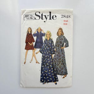 May include: A vintage Style 2848 sewing pattern envelope for size small 8-10. The front features illustrations of four different robe or dress designs, including floral and paisley prints, with some styles featuring hoods and varying sleeve lengths.