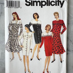 May include: A Simplicity sewing pattern envelope with illustrations of five dress designs. The dresses include a black and white floral print, a white dress, a black dress, a red dress with white trim, and a red dress with black polka dots. The pattern number is 8115.