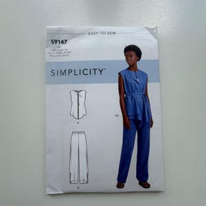 May include: A Simplicity sewing pattern for a two-piece outfit. The pattern features a sleeveless top with a zipper and wide-leg trousers. The image includes a drawing of the outfit and a photo of a person wearing the outfit. The pattern size is UK 10-18.