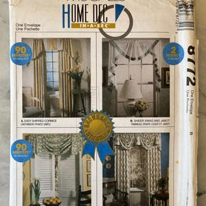 Op de afbeelding: Een vintage McCall's Home Decor naaipatroon envelop. De voorkant toont vier raambekledingsontwerpen: een geplooid fries, sheer swag en jabot, swagged topper en verzamelde federale valance. De envelop heeft een blauw en goud show house lint.