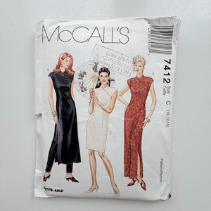 May include: A McCall's 7412 sewing pattern envelope featuring illustrations of three variations of a dress with a mandarin collar and side slits. The envelope displays the text McCall's, 7412, Size C (10, 12, 14), and Petite-Able.