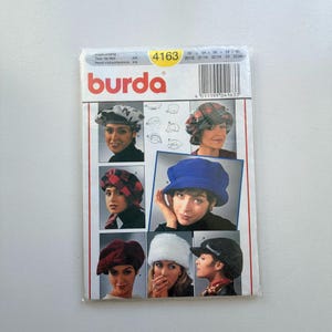 Puede incluir: Un patrón de costura Burda con varios diseños de sombreros. El paquete incluye imágenes de mujeres con diferentes estilos de sombreros, como boinas, cloches y turbantes. El paquete tiene el número 4163 y medidas de circunferencia de la cabeza.