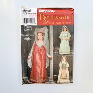 Op de afbeelding: Een Simplicity Renaissance Costume Collection naaipatroon-envelop, nummer 9856, met illustraties van drie verschillende jurken in historische stijl met sluiers en lijfjes in rood, lichtgroen en beige, met maatbereik 7-14 afgedrukt.