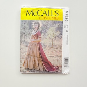 Op de afbeelding: Een McCall's Costumes naaipatroon envelop M7826, maat E5 (14-16-18-20-22). De voorzijde toont een foto van een persoon in een jurk met lange mouwen, een beige rok en een donkerrode overrok en lijfje, met de tekst Angela Clayton erop gedrukt.