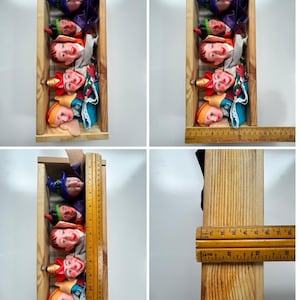 May include: A set of five finger puppets with painted faces and fabric clothing, arranged vertically inside a rectangular wooden box. A wooden ruler shows the box measures approximately 30.5 cm in length and 7.6 cm in width.