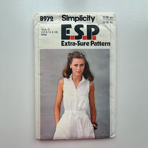 Op de afbeelding: Simplicity ESP Extra-Sure Pattern naaipatroon. Het patroon toont een vrouw in een witte mouwloze jurk met een strik in de taille. Het patroonnummer is 8972 en de maat is O (12, 14 & 16).