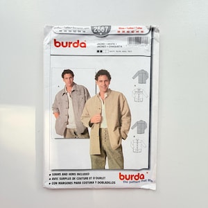 Può includere: Una busta per cartamodello Burda 2667 per una giacca. Il fronte mostra due fotografie di una persona che indossa diversi stili di giacca, insieme a disegni tecnici dei modelli. Il testo include Burda, 2667 e Seams and hems included.