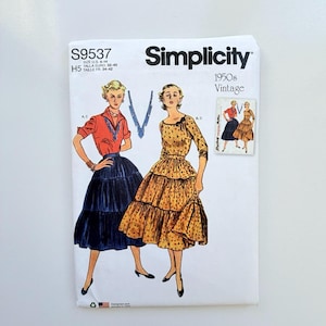 Può includere: Una busta per cartamodello Simplicity S9537 per abbigliamento in stile vintage anni '50. La copertina in carta bianca presenta illustrazioni di due outfit: una camicetta rossa con gonna blu scuro a balze e un abito giallo a fiori con maniche a tre quarti.
