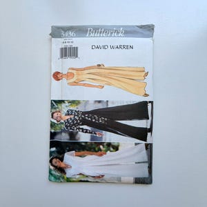 May include: A vintage Butterick sewing pattern featuring illustrations of three different dress designs. The pattern includes the text "DAVID WARREN" and the pattern number "3436". The dresses are in shades of yellow, black, and white.