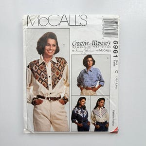 May include: McCall's sewing pattern 6961 for shirts in sizes 10, 12, and 14. The envelope features illustrations of four variations of long-sleeved button-down shirts, including designs with geometric patterned yokes and pleated textures.