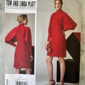 Könnte beinhalten: Vogue Patterns American Designer Tom and Linda Platt V1565 Schnittmuster. Das Schnittmuster zeigt ein rotes Kleid mit hohem Ausschnitt und langen Ärmeln. Größen 6-8-10-12-14.