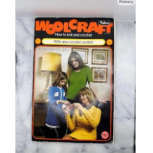 May include: A vintage "Woolcraft" book cover, featuring the text "How to knit and crochet" and "With new crochet section". The cover shows three women, one knitting, and a young girl. The book has an orange and black border.