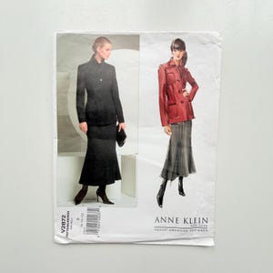 May include: Vogue American Designer sewing pattern V2872 by Anne Klein for sizes 8-10-12. The envelope features a photograph of a black jacket and skirt ensemble and an illustration of a red jacket with a grey skirt, including a barcode and text.