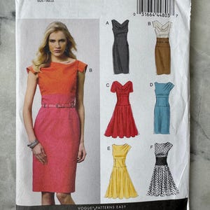 May include: Vogue Patterns Easy Options sewing pattern. The pattern features several dress designs, including a two-tone dress with a pink skirt and orange top. The pattern includes sizes 14-22.