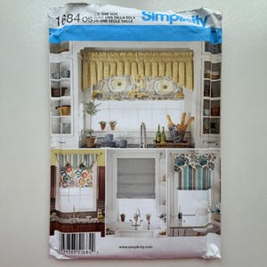 Puede incluir: Patrón de costura Simplicity 1684 OS. El patrón presenta imágenes de cortinas de cocina, incluyendo cenefas y estores romanos. La parte superior del patrón es azul y blanca con la palabra "Simplicity".