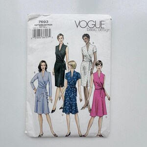 May include: A Vogue Basic Design sewing pattern envelope, number 7693, featuring illustrations of five different wrap dress styles. The designs include variations in sleeve length, neckline, and fabric patterns, labeled A through E on a white background.