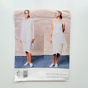 May include: A vintage Donna Karan New York Vogue American Designer sewing pattern. The pattern features two women modeling a white suit and a white dress. The pattern number is 2405, and the size range is 8-10-12.