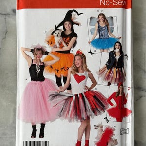 May include: Simplicity No-Sew costume pattern featuring various Halloween and fantasy-themed outfits. The pattern includes designs for a witch, fairy, devil, and other characters. The package displays the number 2074 and the words "ONE SIZE".