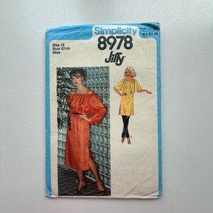 May include: A vintage Simplicity sewing pattern, featuring a woman in an off-the-shoulder orange dress and another in a yellow tunic. The pattern number is 8978, with a bust size of 87cm and size 12.