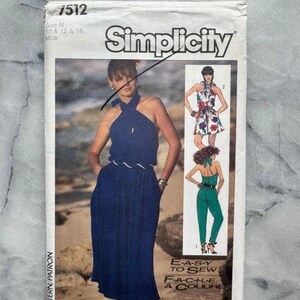 May include: Simplicity sewing pattern 7512. The pattern features a woman in a blue halter dress and two other designs. The text "EASY TO SEW" and "FACILE A COUDRE" are also visible. The pattern is for sizes 10, 12, and 14.