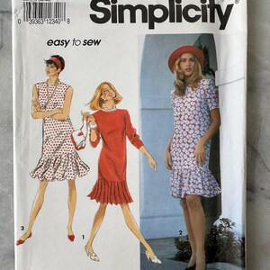 May include: Simplicity sewing pattern 7753, size P (12-16), featuring illustrations of three dresses. The cover shows a red dress, a white dress with red polka dots, and a floral print dress. The text "easy to sew" is also visible.