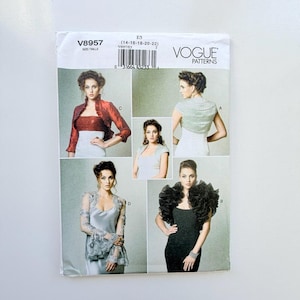 May include: Vogue Patterns V8957 sewing pattern envelope featuring four variations of bolero jackets. The designs include a red ruffled jacket, a silver textured bolero, a light grey cropped jacket, and a black ruffled bolero with a dress.