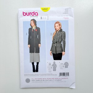 Op de afbeelding: Een Burda Young naaipatroon-envelop, nummer 6847, met twee jasontwerpen. Ontwerp A is een lange, donkergrijze jas met capuchon en ritssluiting. Ontwerp B is een zwart-witte jas met een pied-de-poule patroon, een kraag en een dunne ceintuur.