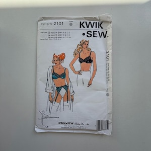 May include: A vintage Kwik Sew sewing pattern, pattern 2101, for lingerie. The pattern features illustrations of a bra and garter belt set. The package includes bra sizes 32-38 with cup sizes A, B, C, D, and garter belt sizes XS-S-M-L.