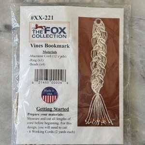 May include: A craft kit for a macrame Vines Bookmark by The Fox Collection, packaged in a clear plastic bag. The label features the product name, a list of materials including 12 yards of cord, one ring, and four beads, plus instructions.