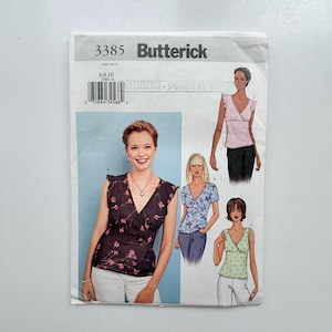 Può includere: Cartamodello Butterick 3385 per un top senza maniche a portafoglio con scollo a V e spalle con volant. La busta mostra tre varianti del top in diverse stampe floreali e colori, tra cui nero, blu e verde chiaro.